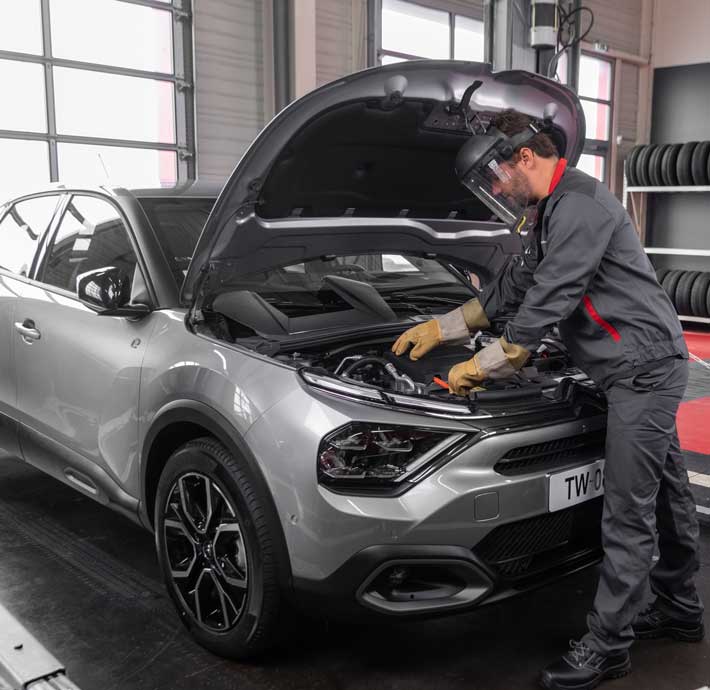 technicien qui controle la batterie d'un vehicule electrique citroen Ë-C4